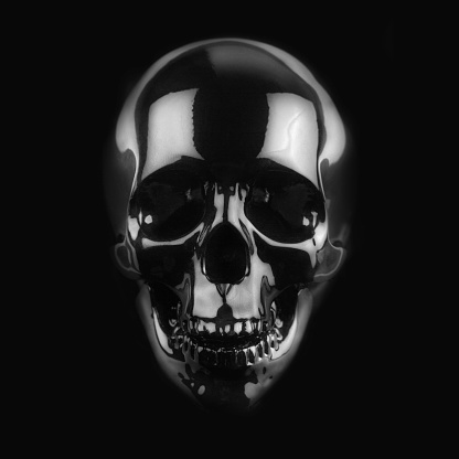 front view of polished shinny wooden skull on dark background