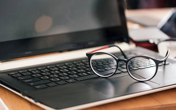 istock Vintage style glasses resting on a black laptop. 841483854