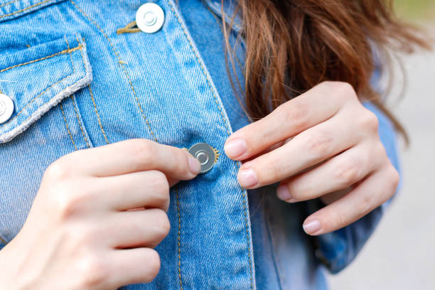 istock Girl buttoning a blue denim shirt. Closeup 841486916