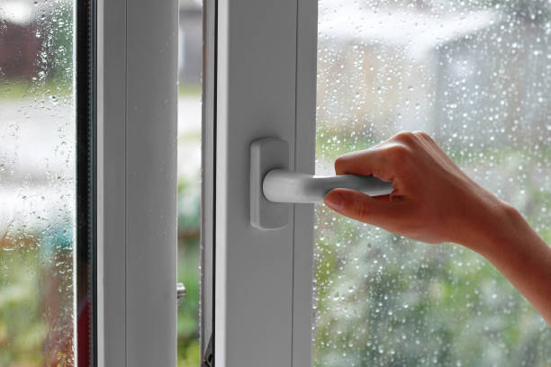 una mano femenina abre una ventana con gotas de agua. cierra la ventana. en el tiempo lluvioso. closeup - la lluvia fuera de la ventana fotografías e imágenes de stock