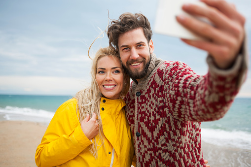 Young couple make selfie at beautiful beach