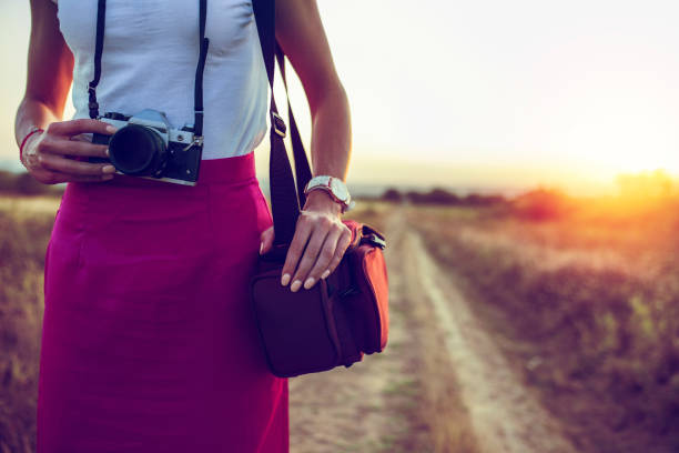 Girl, retro camera and the beautiful sunset on the footpath