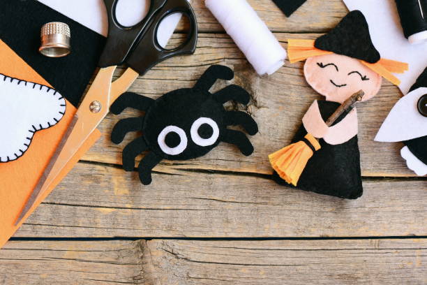 Halloween craft ideas for adults. Halloween crafts for kids. Quick halloween crafts. Halloween craft ideas for toddlers. Halloween crafts decorations. Halloween crafts project. Halloween craft ornament. Halloween crafts ornament manualidades de halloween rápidos. fieltro muñeca de la bruja, decoraciones de araña sobre un fondo de madera vintage. materiales y herramientas de costura. fieltro fácil manualidades de halloween para niños en edad preescolar. vista superior