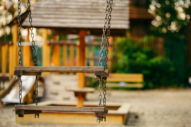 Empty chain swings on playground in the public park close up