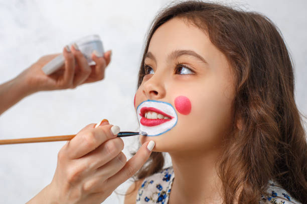 artist doing clown makeup for a little girl - entertainment clown child circus imagens e fotografias de stock