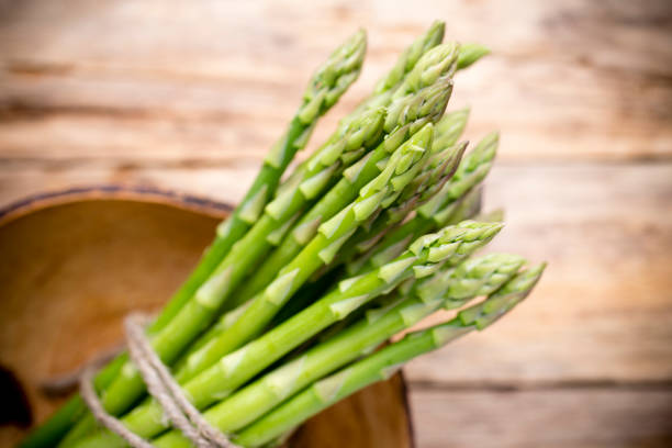 istock Asparagus on the wooden background. 841519314