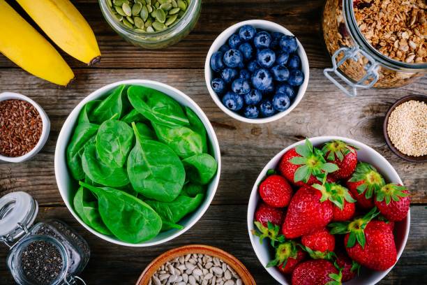 Ingredients for green spinach smoothies: strawberries, bananas, blueberries, seeds