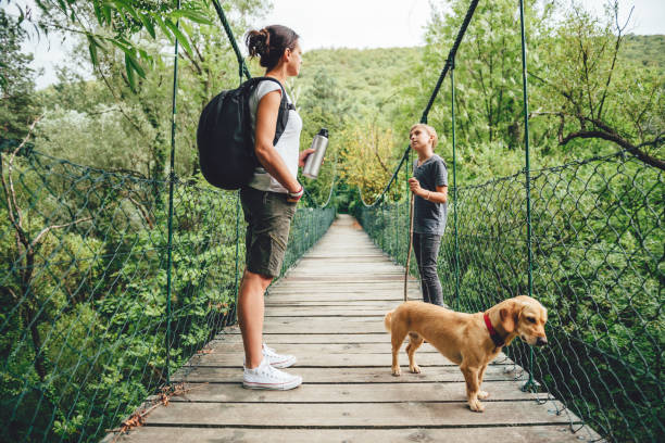 istock Mother and daughter standing on wooden bridge 841523076