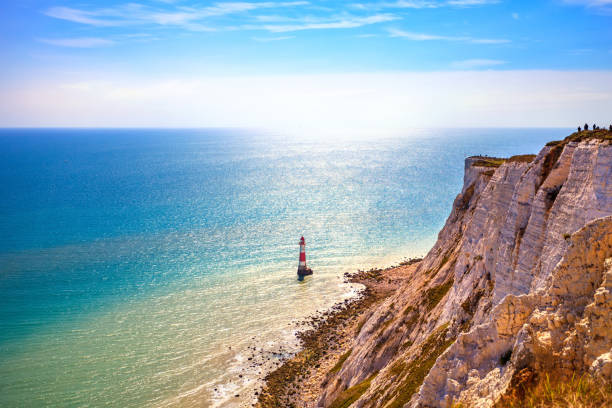 Views of Beachy Head lighthouse from the chalky cliff edge of the south downs on the east Sussex coast south east England UK