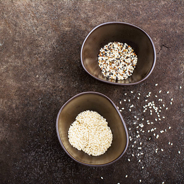 istock Sesame black, brown and white in dark ceramic bowls on a dark background. Top View 841535544