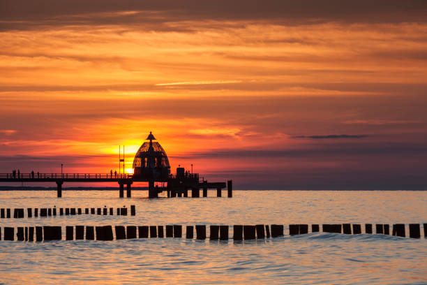 seebrücke zingst mit tauchgondel im sonnenuntergang - beach sunrise waterbreak sea photos et images de collection