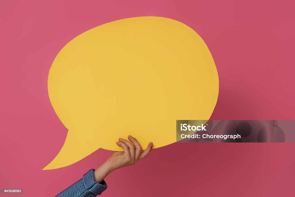 Hand with cartoon speech Hand with cartoon speech on colorful background. Yellow, pink and blue colors. Talking Stock Photo