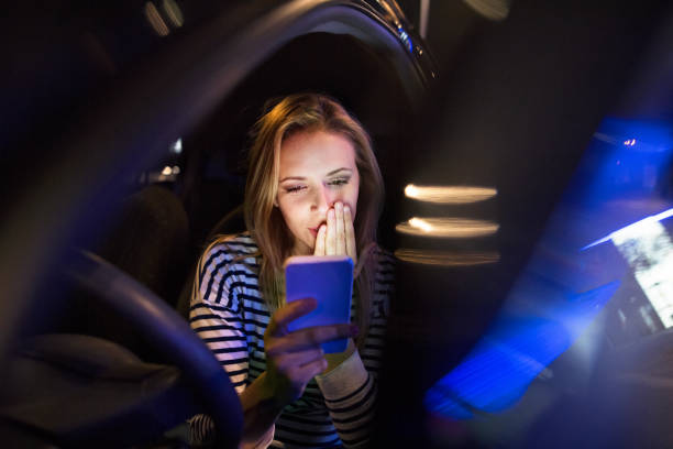 istock Woman with smartphone in her car at night. 841539502