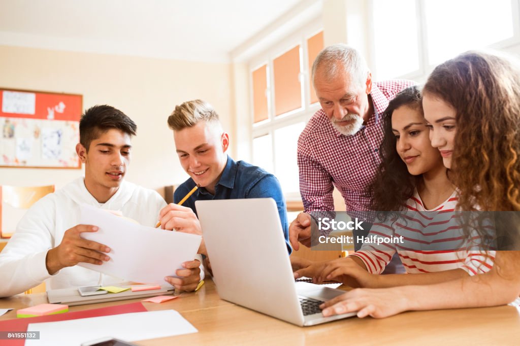 High school students and teacher with laptop. Group of high school student and their teacher with laptop studying. Teacher Stock Photo
