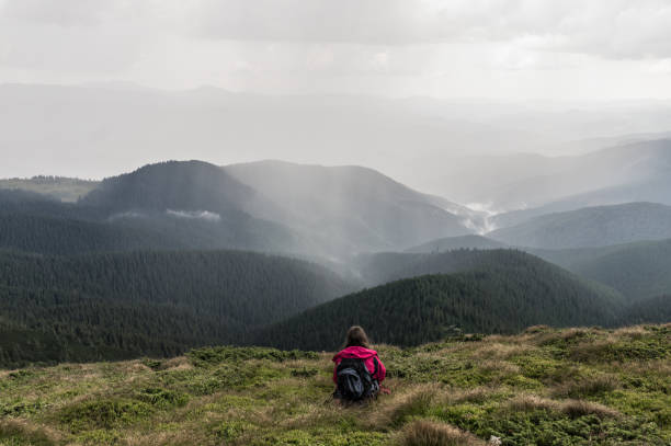 istock Young female hiker with backpack sits in grass on top of hill 841555068