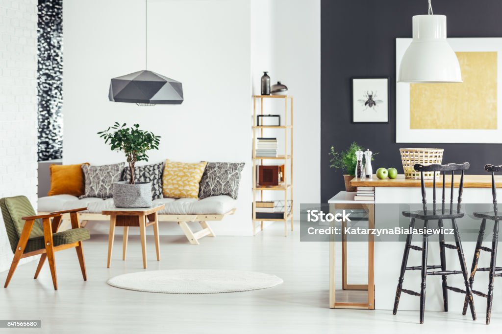 Multifunctional interior with green chair Bar stool at kitchen countertop in multifunctional interior with green chair and sofa Home Showcase Interior Stock Photo