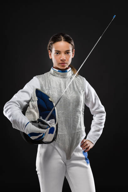 Young woman fencer in white fencing costume stock photo