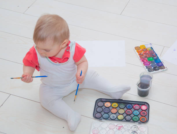istock sitting on the floor babe with watercolor and brush 841577968