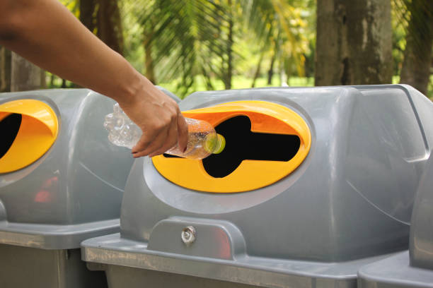 istock Woman hand holding throwing bottle water into the recycle bin 841580636