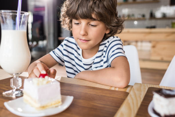 istock cute little boy with piece of cake in cafe 841581380