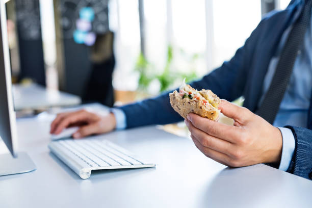 istock Businessman at the desk with computer eating lunch. 841581514