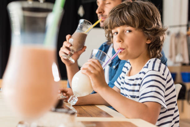 istock cute little son and his father drinking milkshakes in cafe 841581544
