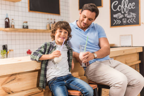 istock cute son and his father drinking milkshakes in cafe 841584014