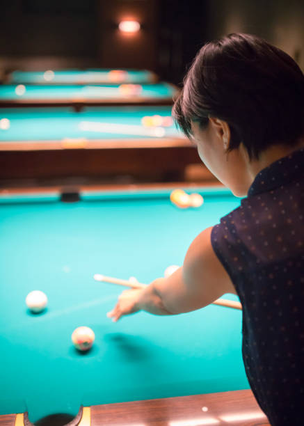 istock Young woman playing billiards 841587740