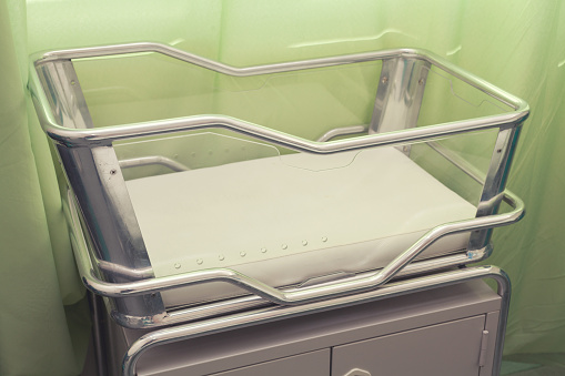 Stainless Steel Hospital Baby Cot with green background