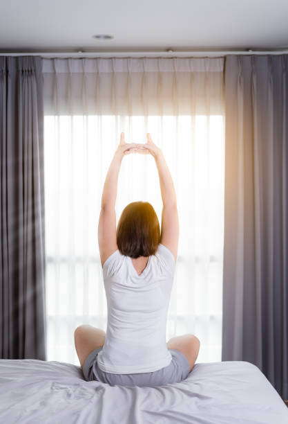 istock Asian Woman stretching in bed after wake up 841592528