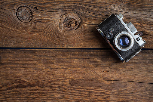 Vintage camera on wooden background. Copy space. Top view.