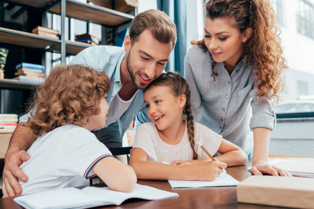 istock beautiful young parents doing homework with kids 841599928