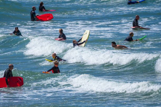 le persone con tavole da surf stanno aspettando l'onda. spiaggia di woolacombe. - woolacombe foto e immagini stock