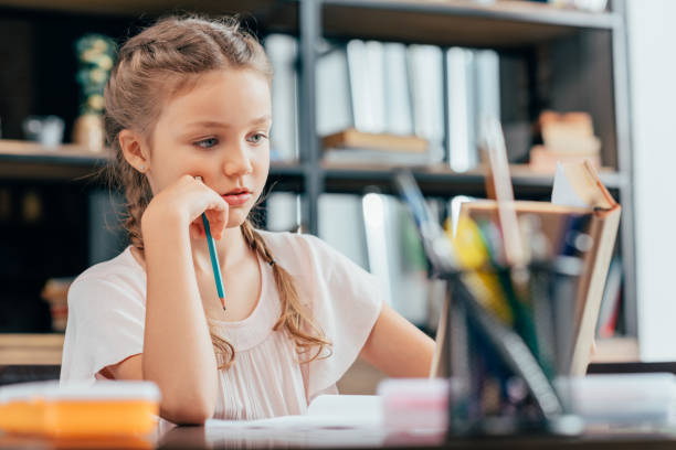 istock focused cute little girl doing homework 841610704