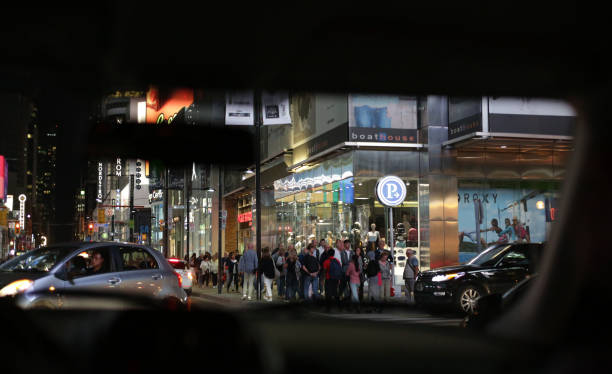 Toronto, Canada - August 18, 2017: Pedestrians walk through Yonge Street's busy shopping district. Bright lights and traffic of the Church-Yonge Corridor on a summer night.