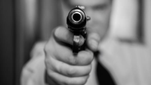istock A hired assassin, a terrorist or a policeman in a black mask with a black combat gun 841613704