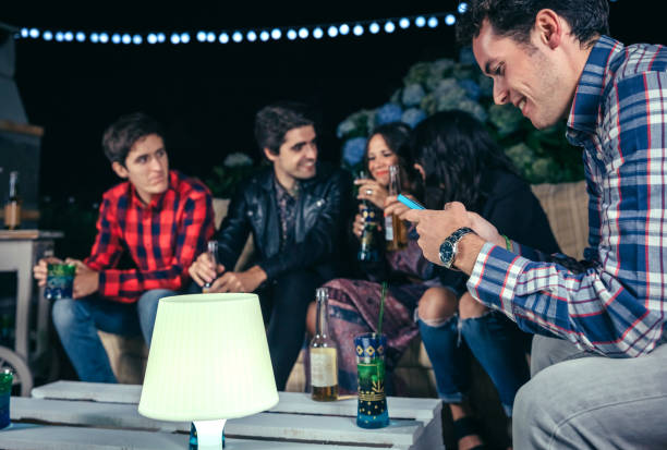 istock Happy man looking smartphone in a party with friends 841614404