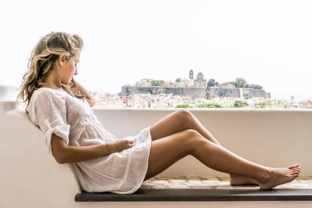 istock Young woman dressed in white relaxing on her terrace 841621558