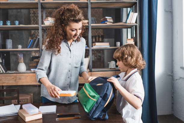 istock adorable young mother and son preparing backpack for school 841625236