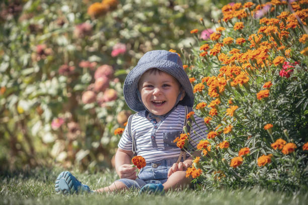 istock Happy little baby boy front or back yard playing with flowers outdoors on grass 841629132