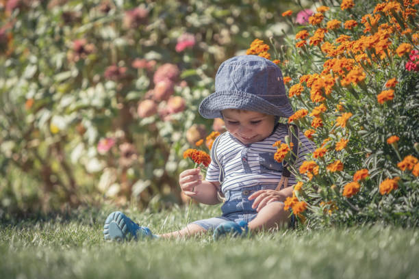 istock Happy little baby boy front or back yard playing with flowers outdoors on grass 841629364