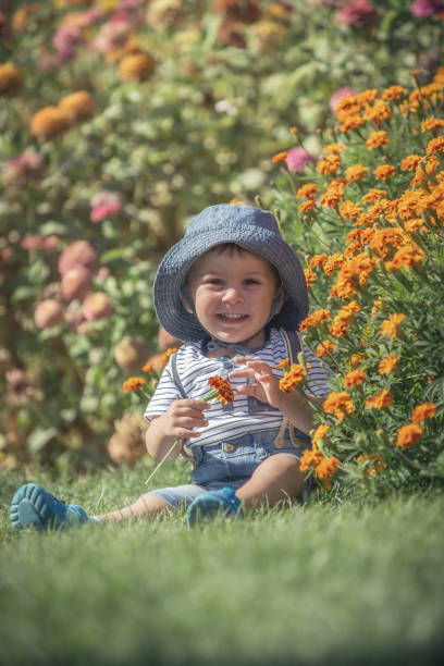 istock Happy little baby boy front or back yard playing with flowers outdoors on grass 841632360