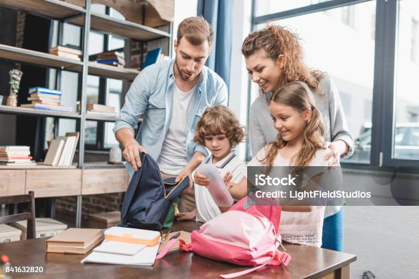 Genitori Imballaggio Bambini Per Il Loro Primo Giorno A Scuola - Fotografie stock e altre immagini di Riapertura delle scuole