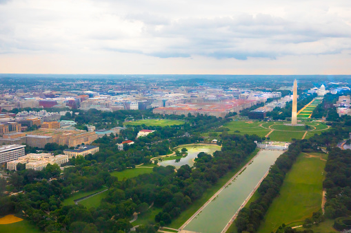 Aerial shot taken from an airplane of Washington DC shows the Washington Monument and the National Mall and reflecting pool. Shot taken with Canon 5D Mark lV on a cloudy day.