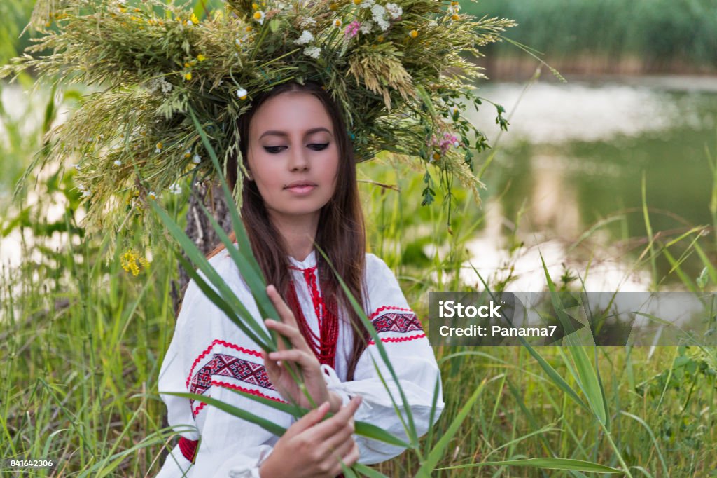 Belle fille en chemise de broderie et une guirlande de fleurs sauvages. - Photo de Adulte libre de droits