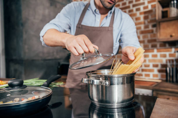 istock cropped shot of man with apron cooking pasta 841642434