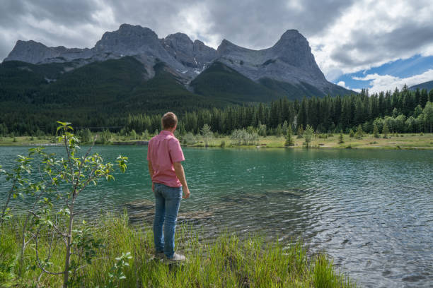 istock Young man contemplating nature from lakeshore 841642514