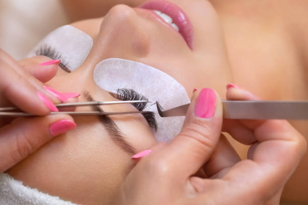Beautiful Woman with long eyelashes in a beauty salon. Eyelash extension procedure Beautiful Woman with long eyelashes in a beauty salon. Eyelash extension procedure. Lashes close up mink fur stock pictures, royalty-free photos & images