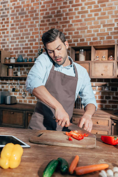 istock handsome young man cooking and talking by phone 841646164