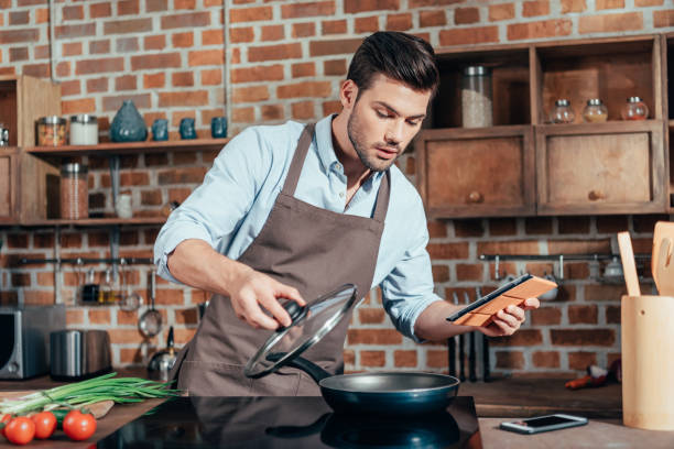 istock handsome young man cooking with digital tablet 841646222